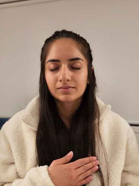 Hands resting over the heart in a quiet moment of stillness